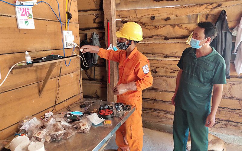 Công nhân Công ty Điện lực Kon Tum hướng dẫn cho người dân làng Dao, xã Ia Dom, huyện Ia H’Drai cách sử dụng điện an toàn. 