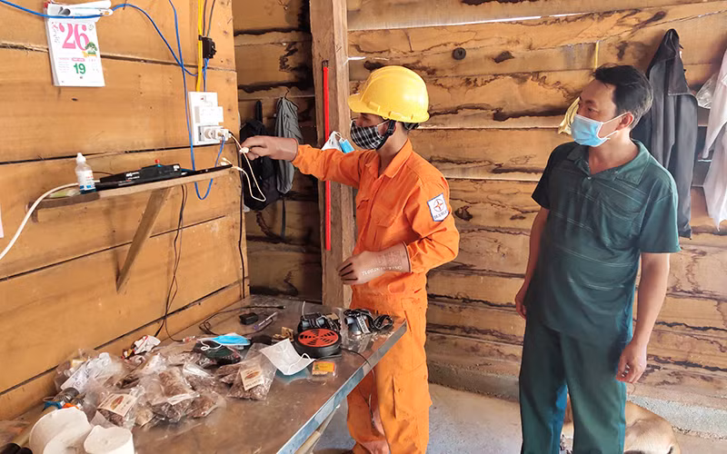 Công nhân Công ty Điện lực Kon Tum hướng dẫn cho người dân làng Dao, xã Ia Dom, huyện Ia H’Drai cách sử dụng điện an toàn. 