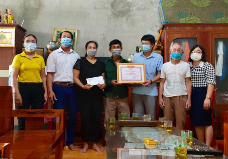 Lãnh đạo xã Đặng Sơn trao giấy khen và tiền thưởng cho vợ chồng ông Ngô Văn Nam. 