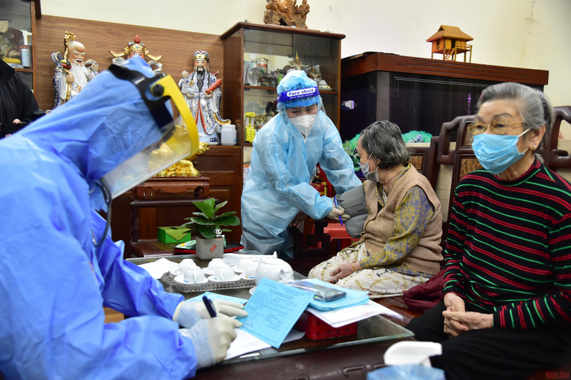 Nhân viên y tế triển khai tiêm chủng cho người dân tại nhà. (Ảnh: THÀNH ĐẠT)