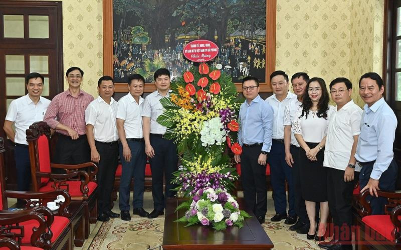 Tổng Biên tập Lê Quốc Minh cùng lãnh đạo Báo Nhân Dân đón nhận lẵng hoa chúc mừng của đoàn đại biểu Thành ủy, HĐND, UBND, Ủy ban MTTQ Việt Nam TP Hải Phòng. (Ảnh: DUY LINH)