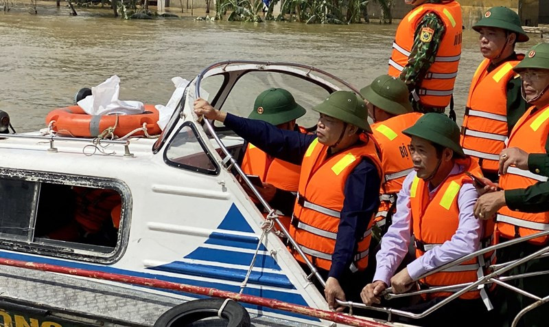 Bộ trưởng Nông nghiệp và Phát triển nông thôn, Phó Ban chỉ đạo T.Ư về Phòng chống thiên tai Nguyễn Xuân Cường đi cano kiểm tra vùng lũ Lệ Thủy, Quảng Bình ngày 22-10. Ảnh: HƯƠNG GIANG.