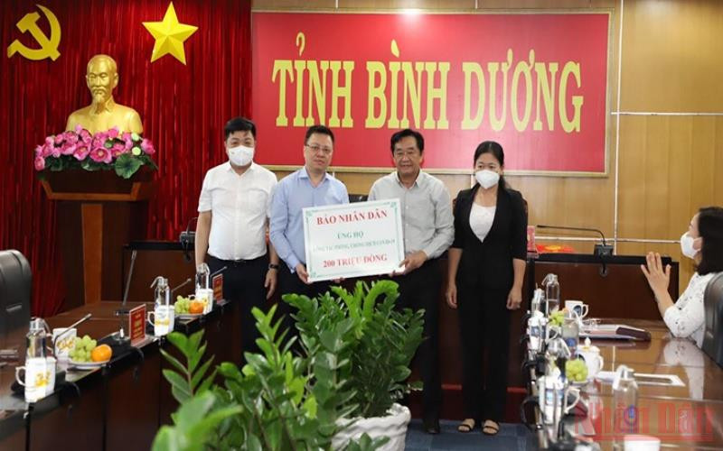 Tổng Biên tập Báo Nhân Dân Lê Quốc Minh trao 200 triệu đồng của Báo Nhân Dân ủng hộ tỉnh Bình Dương phòng, chống dịch bệnh Covid-19.