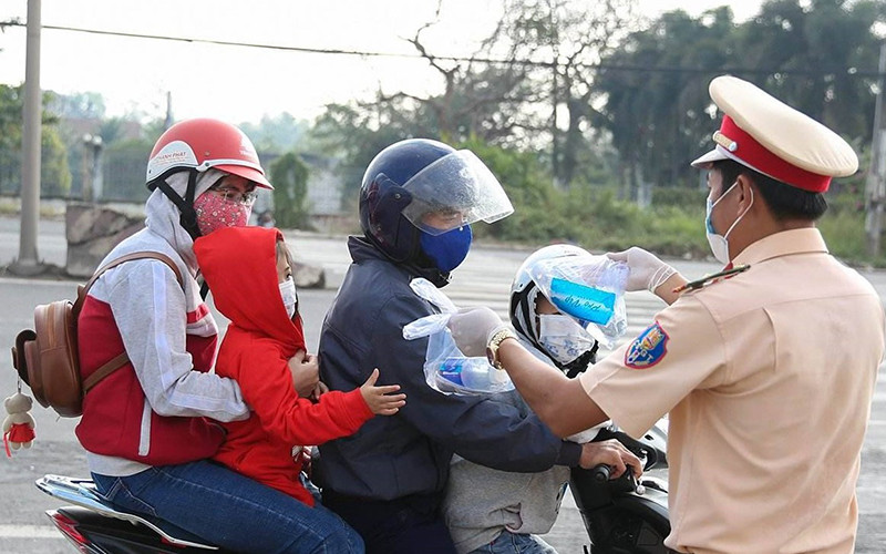 Lực lược CSGT phát khẩu trang, nước uống, khăn lạnh cho người dân trên quốc lộ 51.