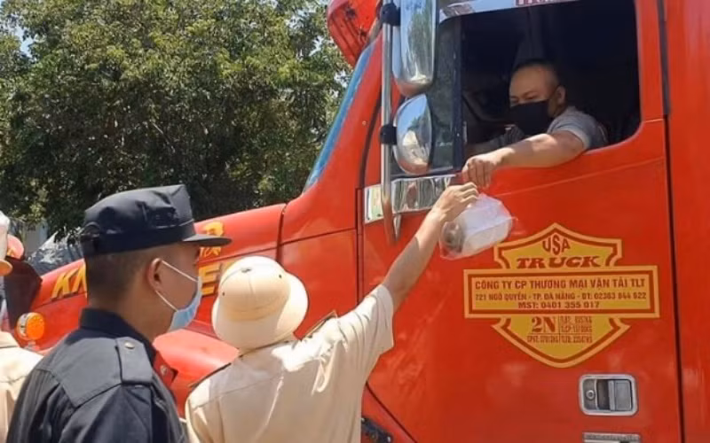 Cảnh sát giao thông phát cơm hộp ăn trưa cho lái xe đường dài bắc - nam tại thị trấn Lăng Cô (huyện Phú Lộc, tỉnh Thừa Thiên Huế)