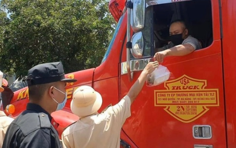 Cảnh sát giao thông phát cơm hộp ăn trưa cho lái xe đường dài bắc - nam tại thị trấn Lăng Cô (huyện Phú Lộc, tỉnh Thừa Thiên Huế)