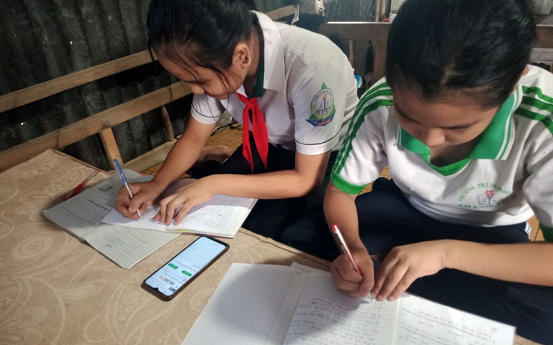 Nhiều học sinh thiếu thiết bị học trực tuyến, phải học chung bằng điện thoại di động.