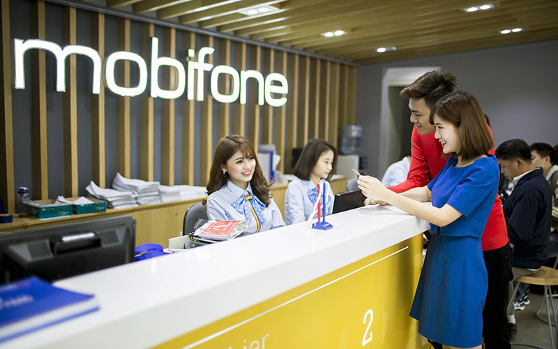 Khách hàng làm thủ tục giao dịch tại cửa hàng của Mobifone. (Ảnh TUẤN TÚ) 