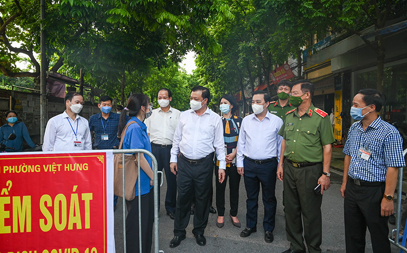 Bí thư Thành uỷ Đinh Tiến Dũng thăm hỏi, động viên lực lượng làm nhiệm vụ tại chốt kiểm soát dịch Covid-19 làng Lệ Mật, phường Việt Hưng (Long Biên). Ảnh: Duy Linh.