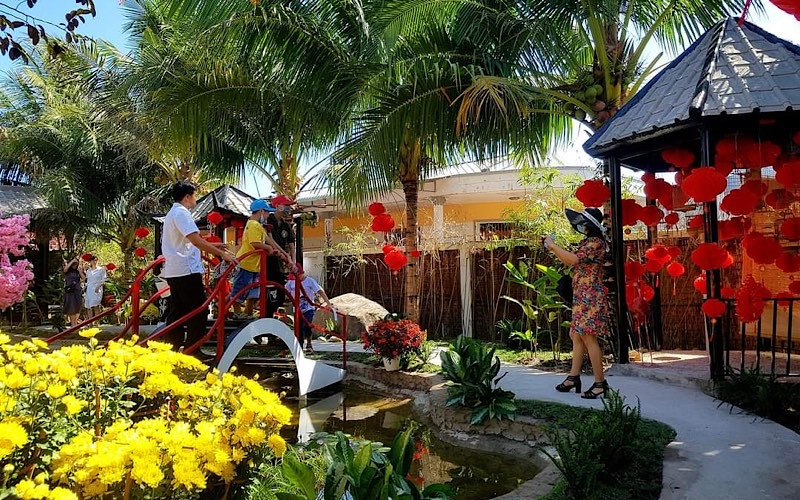 Du khách thích thú chụp ảnh lưu niệm tại làng du lịch Ông Đề.