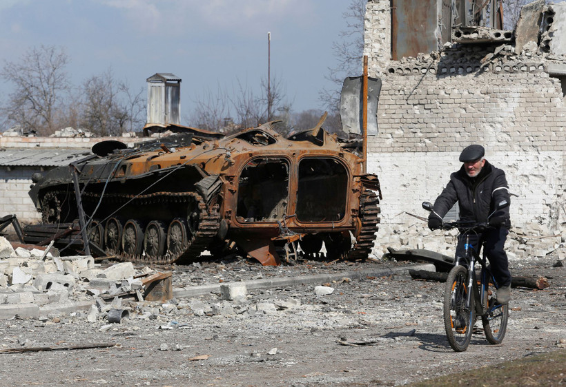 Người dân đạp xe qua một khu vực tại vùng Donetsk, Ukraine, ngày 15/3. (Ảnh: Reuters)