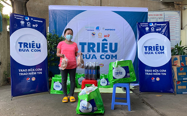 Người dân ở Liên khu 1-6, Bình Trị Đông, TP Hồ Chí Minh nhận quà hỗ trợ khẩn cấp của AFV và CARE quốc tế tại Việt Nam (Ảnh: AAV).