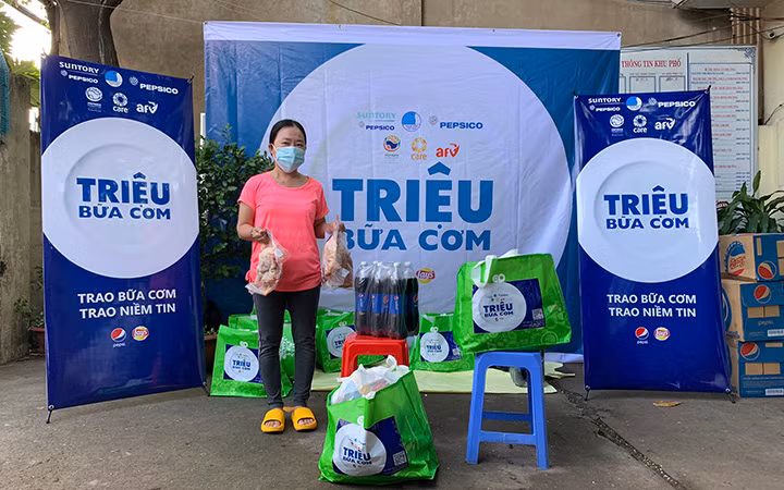 Người dân ở Liên khu 1-6, Bình Trị Đông, TP Hồ Chí Minh nhận quà hỗ trợ khẩn cấp của AFV và CARE quốc tế tại Việt Nam (Ảnh: AAV).