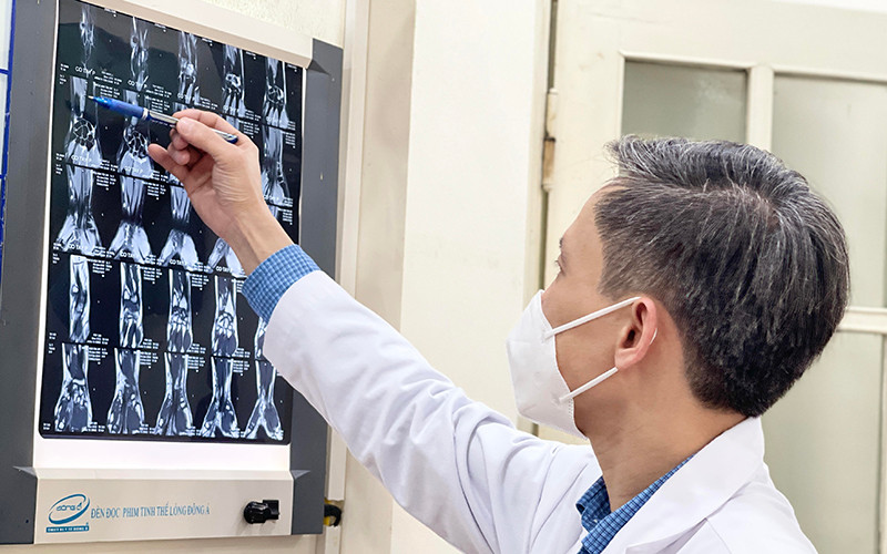 PGS,TS Nguyễn Mạnh Khánh xem hình ảnh MRI của bệnh nhân trước khi tiến hành phẫu thuật nội soi. 