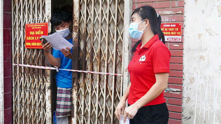 Cán bộ y tế hướng dẫn người dân về việc cách ly y tế tại nhà. Ảnh: NGUYỄN KIM