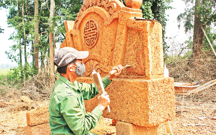 Nghệ nhân tỉ mỉ điêu khắc cuốn thư.