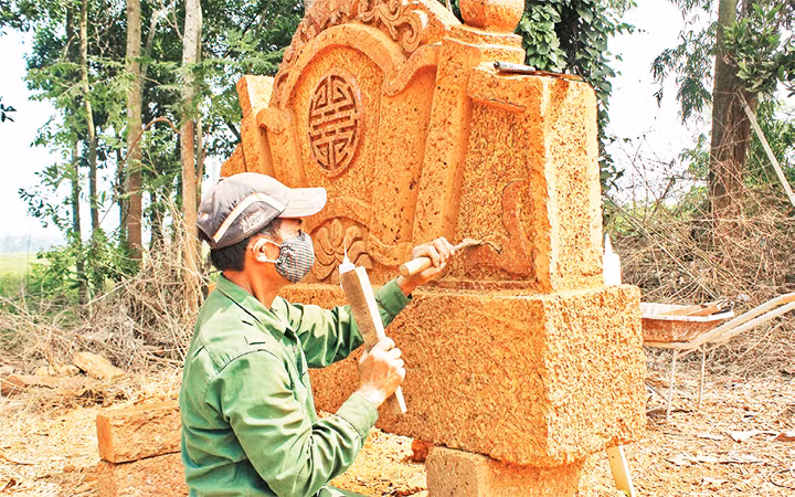 Nghệ nhân tỉ mỉ điêu khắc cuốn thư.