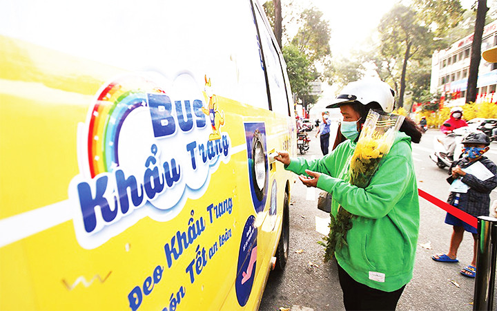 Người dân nhận khẩu trang kháng khuẩn miễn phí từ xe buýt khẩu trang tự động.