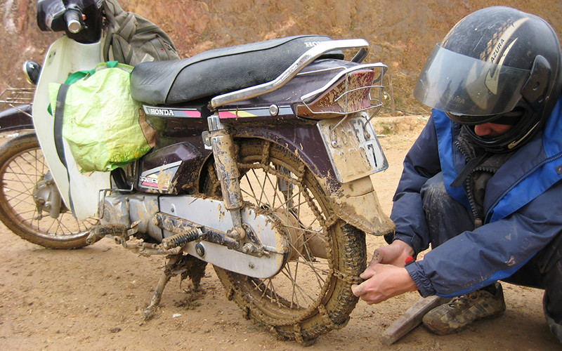 Để đi được trong mùa mưa, xe máy của các thầy cô giáo phải cuốn thêm xích.