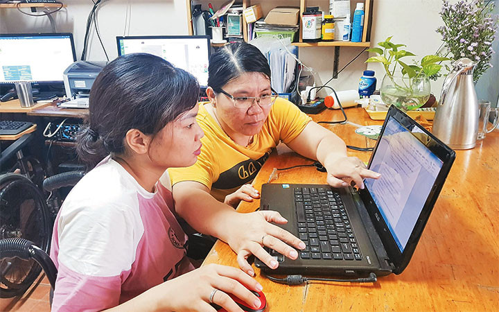 Chị Nguyễn Thị Mỹ Ngọc (áo vàng) bị liệt hai chân, là tấm gương làm kinh tế giỏi và giải quyết việc làm cho nhiều người khuyết tật.