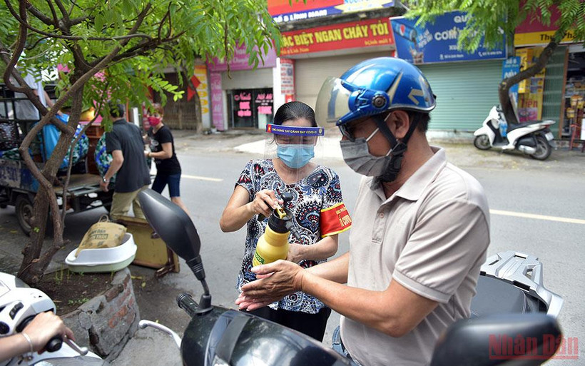 Xịt khử khuẩn cho người dân tại "vùng xanh" ở Mai Động, quận Hoàng Mai (Hà Nội). Ảnh: DUY LINH