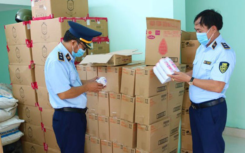 Cán bộ quản lý thị trường Quảng Bình kiểm tra số hàng hóa có dấu hiệu nhập lậu bị thu giữ.