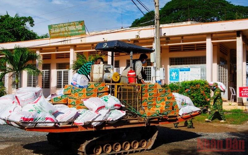 Chuyển quà lên xe hỗ trợ chính quyền và bà con Việt kiều tại xã Cô Rô Ca, huyện Pèm Chô, tỉnh Prey veng, Campuchia. (Ảnh: PHÚ QUÝ)