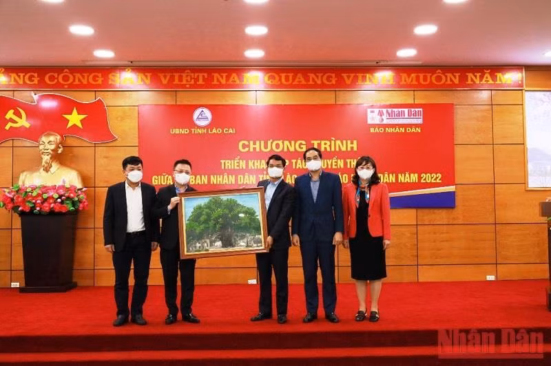 Tổng Biên tập Báo Nhân Dân Lê Quốc Minh trao bức tranh lưu niệm cho lãnh đạo tỉnh Lào Cai.