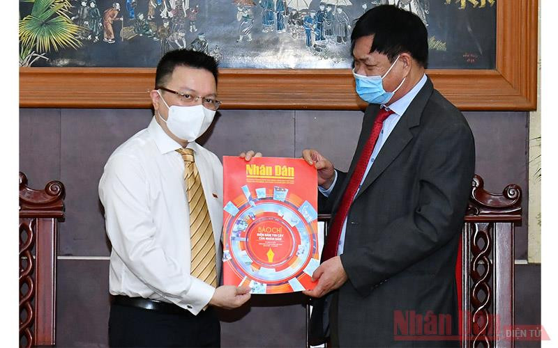 Đồng chí Lê Quốc Minh tặng đồng chí Huỳnh Tấn Việt (bên phải) số báo đặc biệt nhân ngày 21-6. (ẢNH: THỦY NGUYÊN)
