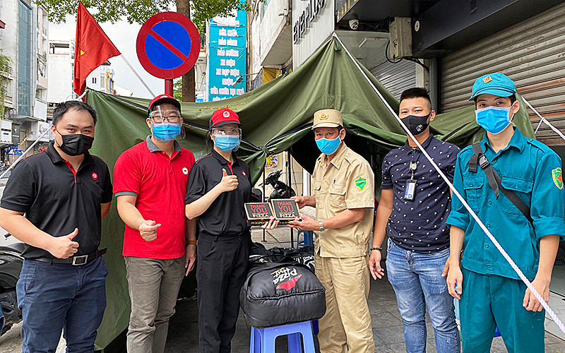 Những suất ăn gồm pizza và đồ uống được vận chuyển đến tặng các chốt kiểm soát dịch bệnh tại phường Văn Chương (quận Đống Đa, TP Hà Nội).