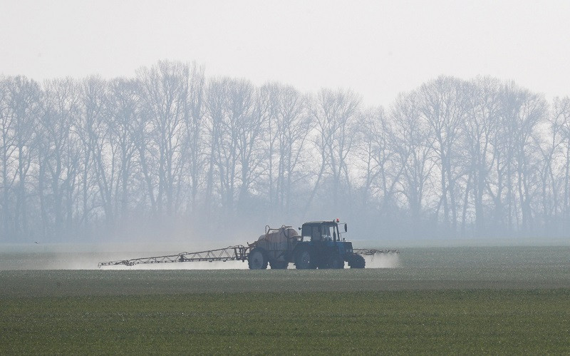 Máy kéo rải phân bón trên cánh đồng lúa mì vụ đông gần làng Husachivka ở vùng Kiev, Ukraine, ngày 17/4/2020. (Ảnh: REUTERS)