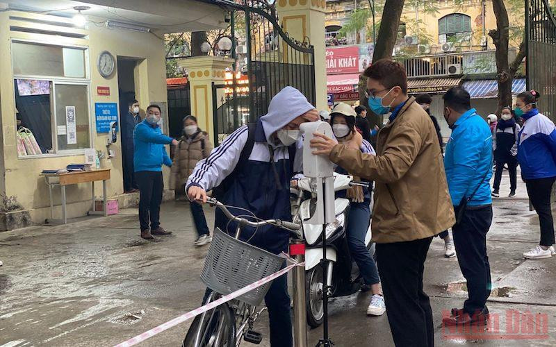 Kiểm tra thân nhiệt cho học sinh trước khi vào lớp tại Trường THPT Việt Đức (quận Hoàn Kiếm, Hà Nội).