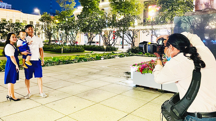 Ông Nam đang chụp ảnh cho một gia đình.