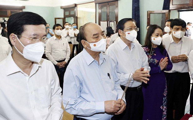 Chủ tịch nước Nguyễn Xuân Phúc và các thành viên trong đoàn thành kính dâng hoa, dâng hương tại Nhà 67. (Ảnh: TTXVN)