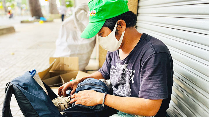 Anh Đòng đang gói kỹ những phần bánh nhà hảo tâm trao tặng để làm quà gửi về quê cho con gái.