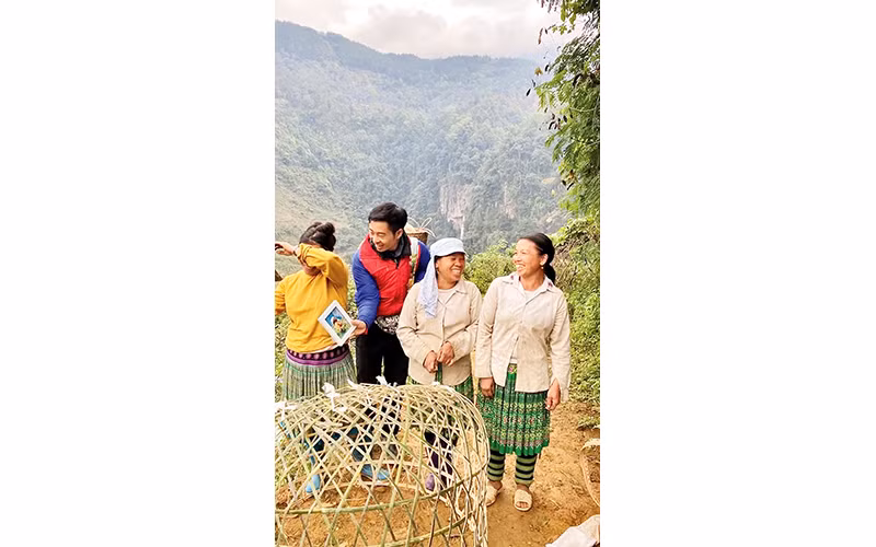 Lưu Minh Khương tặng ảnh cho người dân ở Yên Bái.