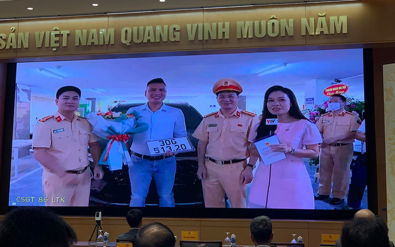 Phòng CSGT Hà Nội trao biển số ô-tô cho anh Nguyễn Việt Hưng - công dân đầu tiên thực hiện thành công dịch vụ công thứ 1.000 trên Cổng Dịch vụ công quốc gia. Ảnh: Quang Hiếu