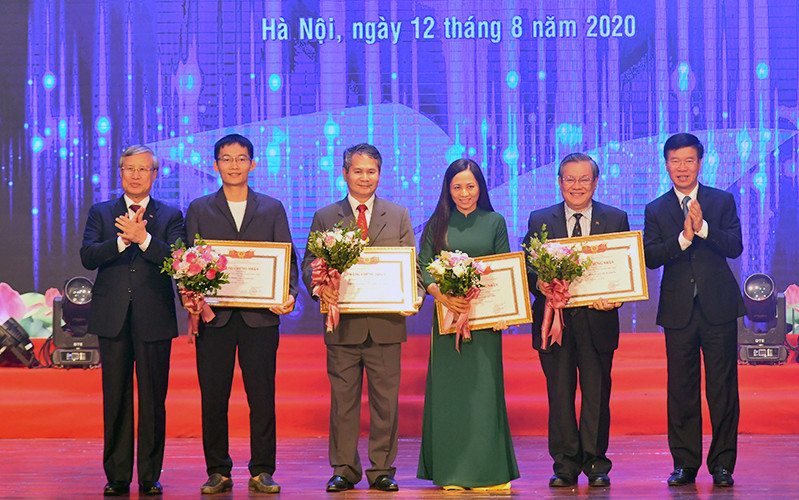 Ðồng chí Trần Quốc Vượng và đồng chí Võ Văn Thưởng trao giải A cho các tác giả. Ảnh: DUY LINH