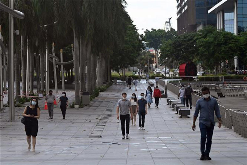 Người dân đeo khẩu trang phòng dịch Covid-19 tại Vịnh Marina, Singapore. (Ảnh: AFP/TTXVN)