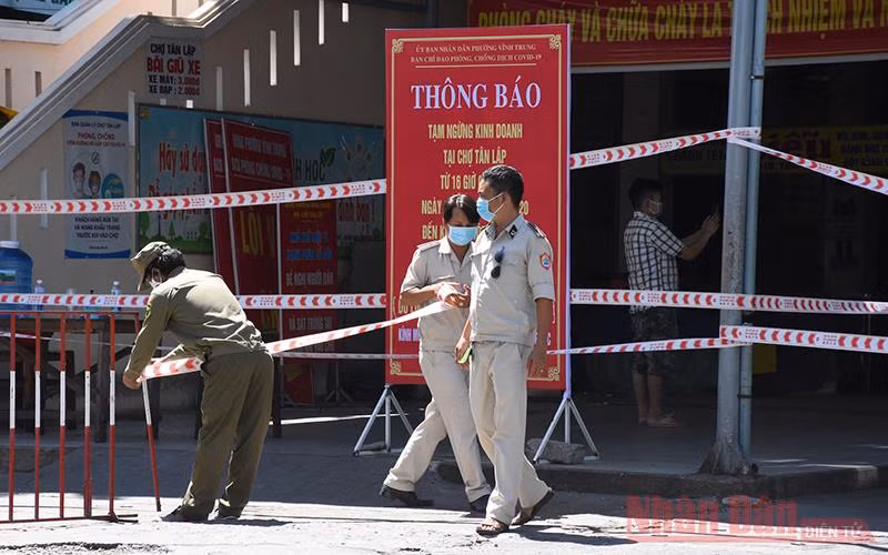 Lực lượng chức năng đặt barie chốt phong toả phía trước cổng chợ Tân Lập sáng 22-8.