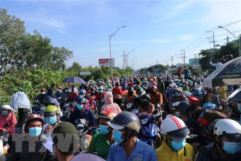 Hàng nghìn người dân chờ đợi qua chốt kiểm soát dịch trên Quốc lộ 1 (giáp ranh Long An và Tiền Giang) để về quê. (Ảnh: TTXVN)