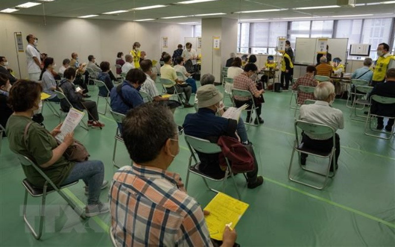 Người dân xếp hàng chờ tiêm vaccine phòng Covid-19 tại Tokyo (Nhật Bản), ngày 24/5/2021. (Ảnh: AFP/TTXVN)