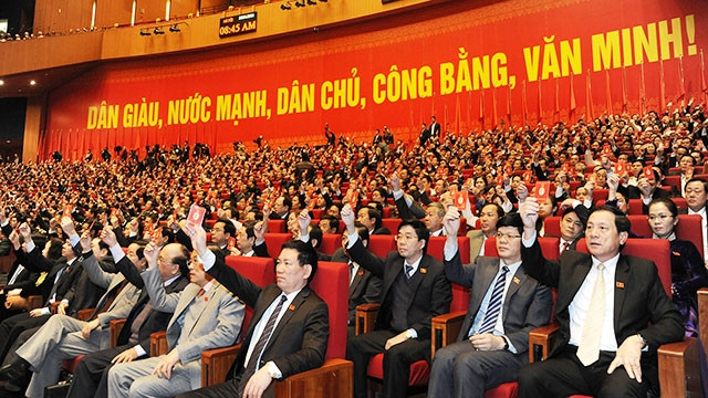 Các đại biểu biểu quyết thông qua Nghị quyết Đại hội lần thứ XII của Đảng. Ảnh: TRẦN HẢI