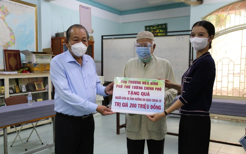 Phó Thủ tướng Thường trực Chính phủ Trương Hòa Bình và đại diện đơn vị tài trợ trao bảng tượng trưng, tặng quà cho ông Kim Sô, Giáo cả Thánh đường Anwar.