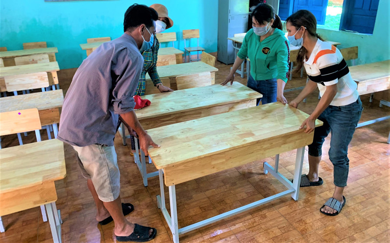 Giáo viên và phụ huynh Trường tiểu học Bùi Thị Xuân, xã vùng sâu Ea M’Droh, huyện Cư M’gar chuẩn bị bàn ghế đón học sinh đến trường học tập.