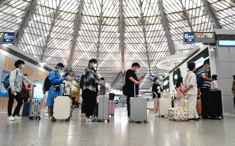 Hành khách xếp hàng lên chuyến tàu D2152 ở ga Nam Thượng Hải trong ngày đầu mở cửa trở lại. (Ảnh: Tân Hoa Xã)