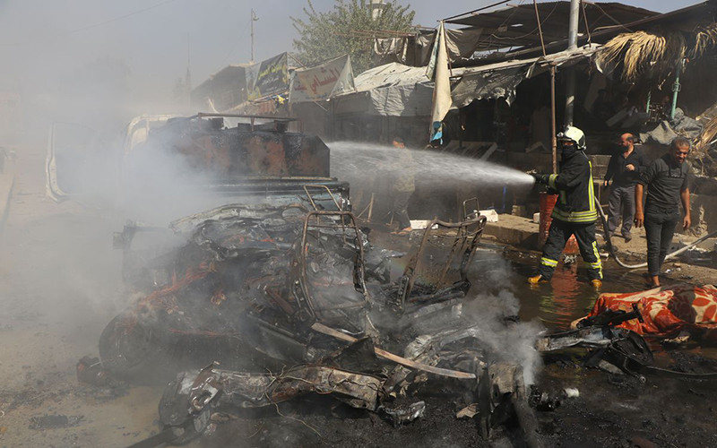 Nhân viên cứu hỏa dập đám cháy trên xe ô-tô tại Afrin, Syria, ngày 11/10/2021. (Ảnh: Reuters)