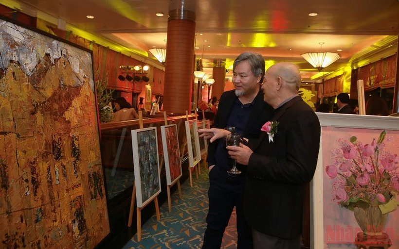 Người xem thích thú trao đổi về những bức tranh đẹp tại triển lãm.