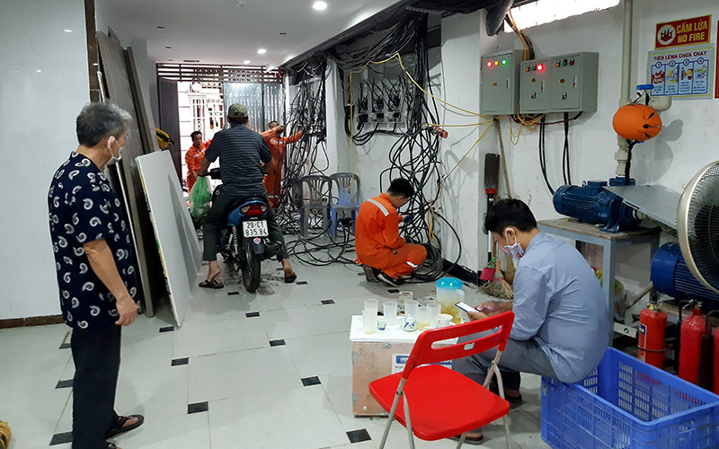 Nhân viên điện lực lắp đặt đồng hồ ở một chung cư mini trên địa bàn quận Ðống Ða.