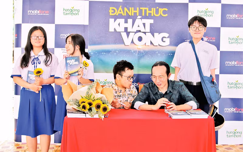 Diễn giả Nguyễn Sơn Lâm (ngồi giữa) và Nhạc sĩ Hà Chương ký tặng sách cho học sinh Trường THPT Gò Vấp, TP Hồ Chí Minh tại chương trình "Ðánh thức khát vọng".